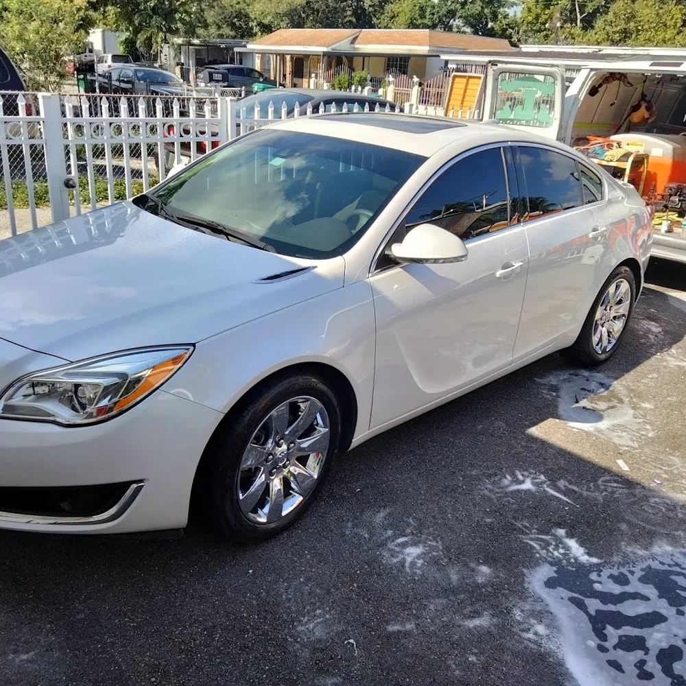 Real photo of white Buick sedan undergoing foam hand wash at Nate's the Great