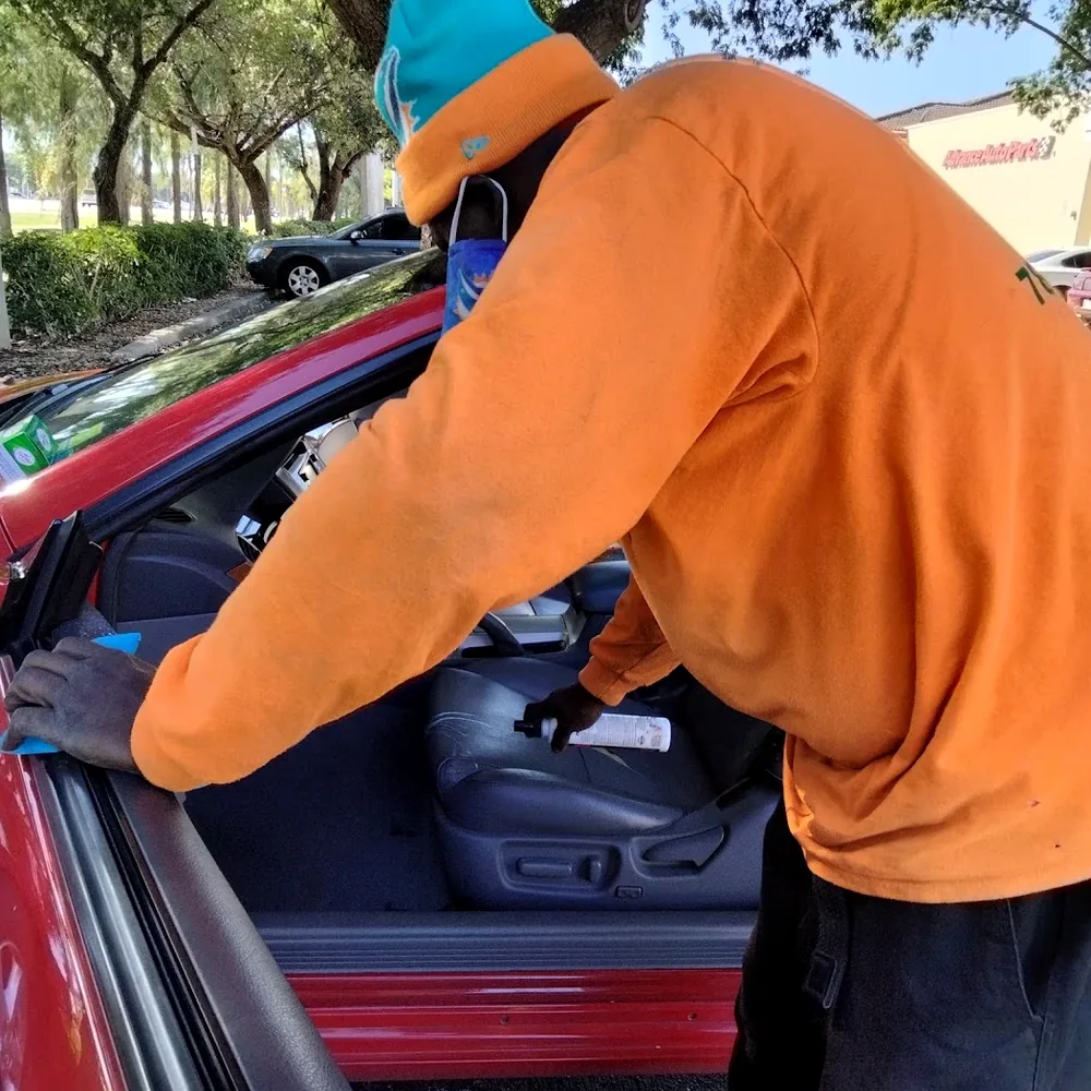 Real photo of Mr. Nate conditioning red coupe leather interior in Miami